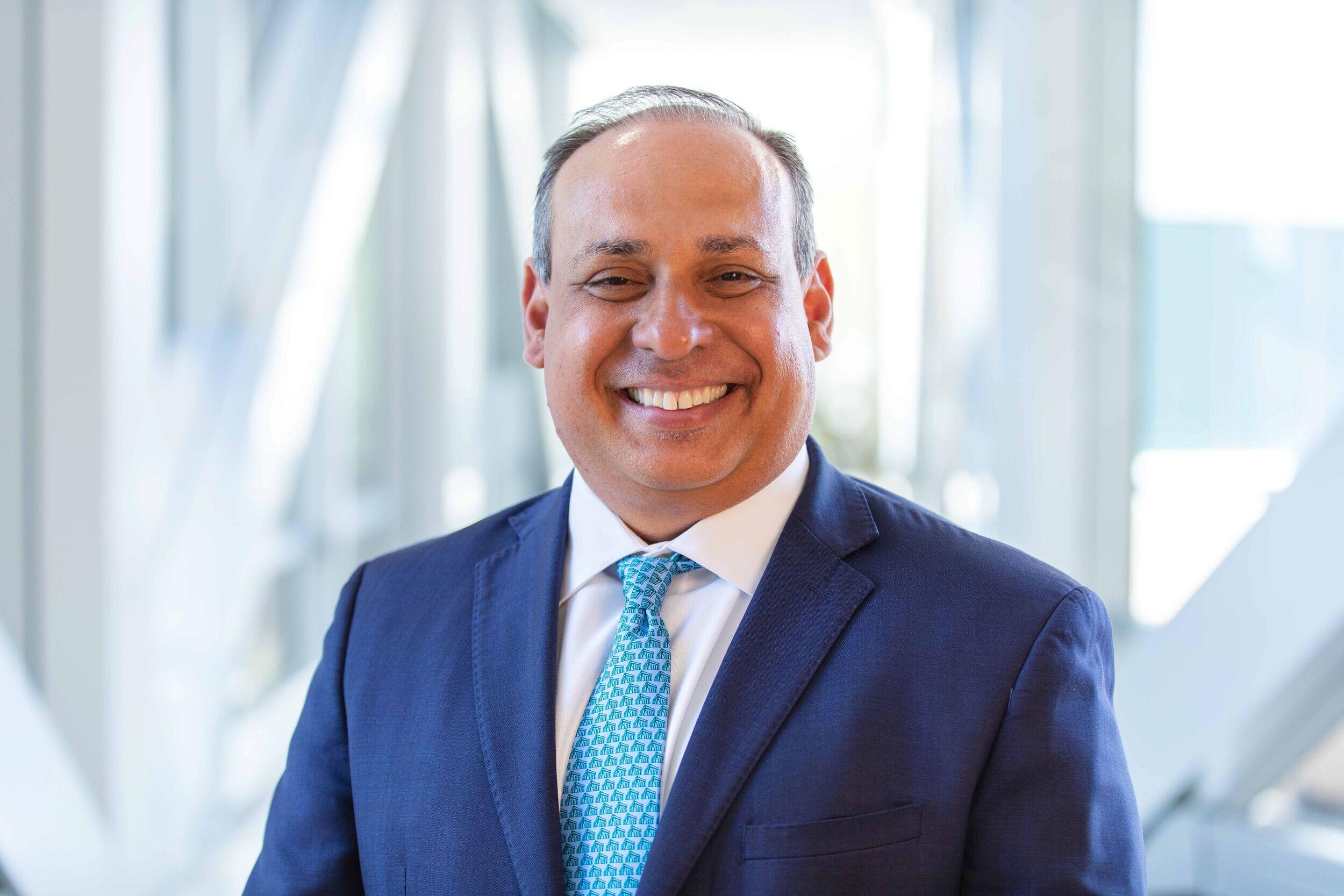 A smiling man in a coat and tie.