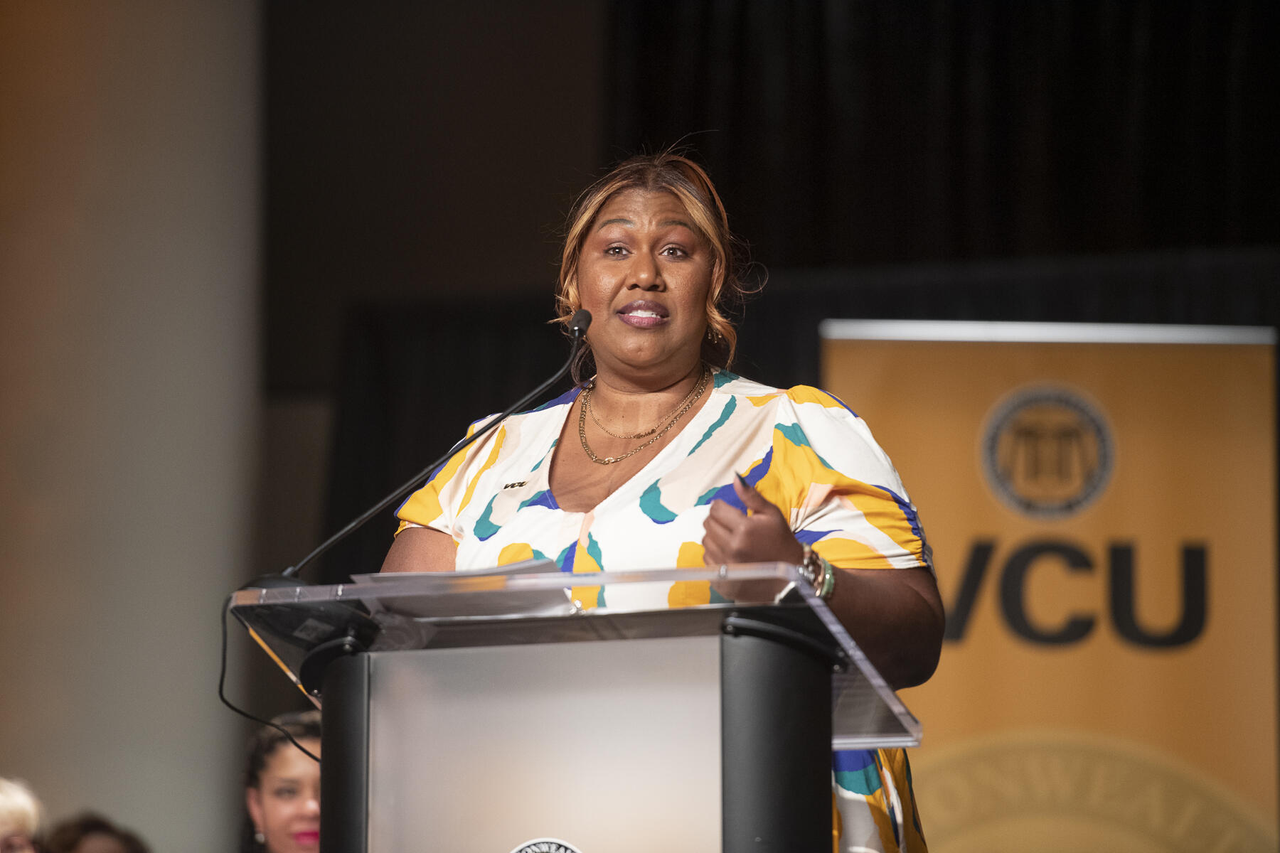 A woman standing at a podium speaking. 