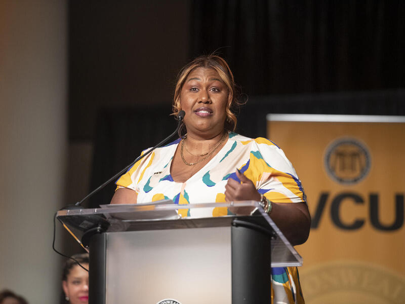 A woman standing at a podium speaking. 