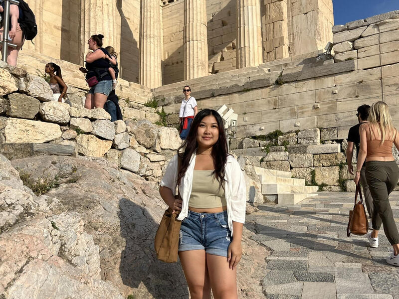 A photo of a woman standing on ancient roman ruins 