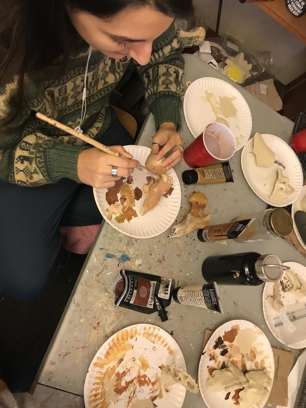  Isabel Griffin, a senior communication arts major and Virtual Curation Laboratory manager, paints a 3-D-printed replica of a bone fragment from the collection of the National Museum of Health and Medicine. (Photo by Brian McNeill, University Relations)
