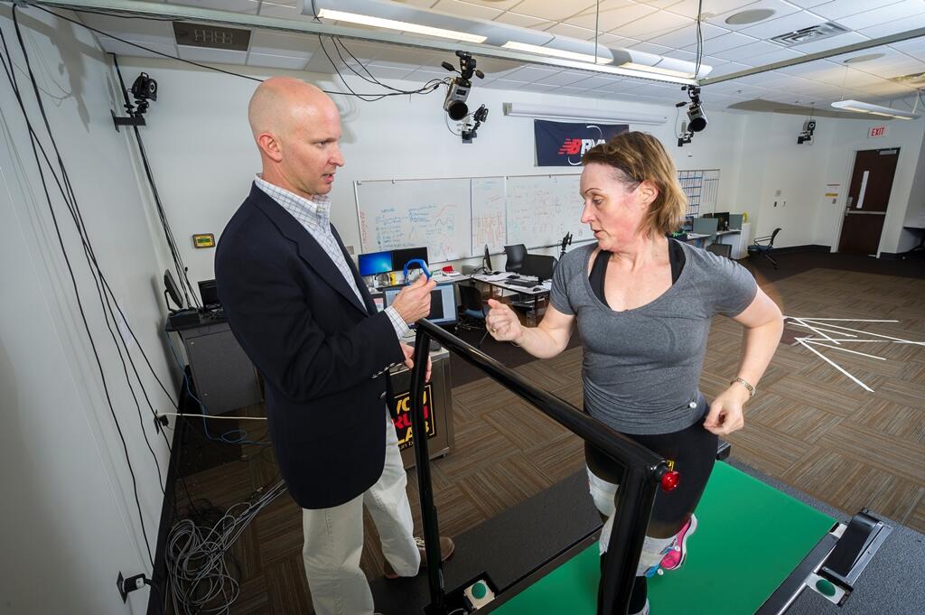 D.S. Blaise Williams III, Ph.D., founder and director of the VCU RUN LAB, checks Paige Fitzgerald’s pace on the lab’s treadmill. 
