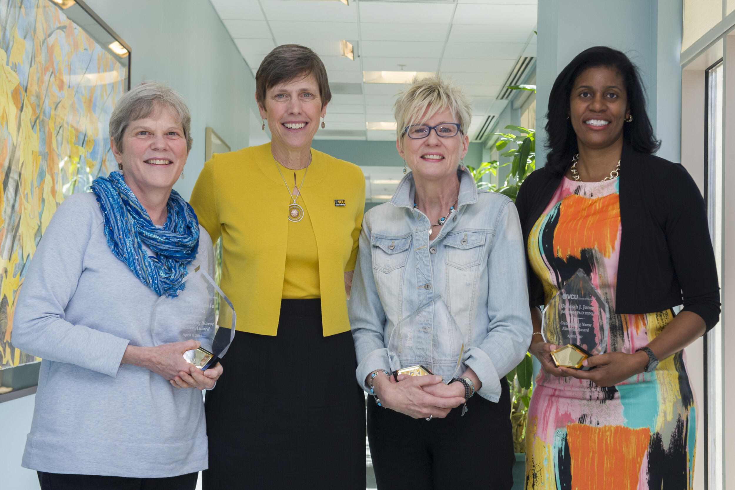 A photo of four woman standing next to each other 