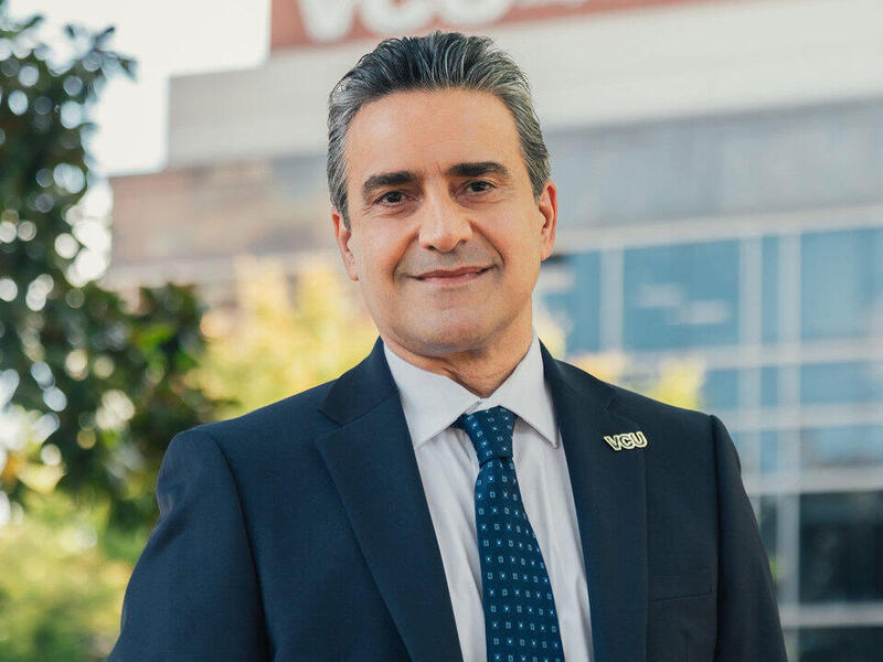 A photo of a man in a suit from the chest up. 