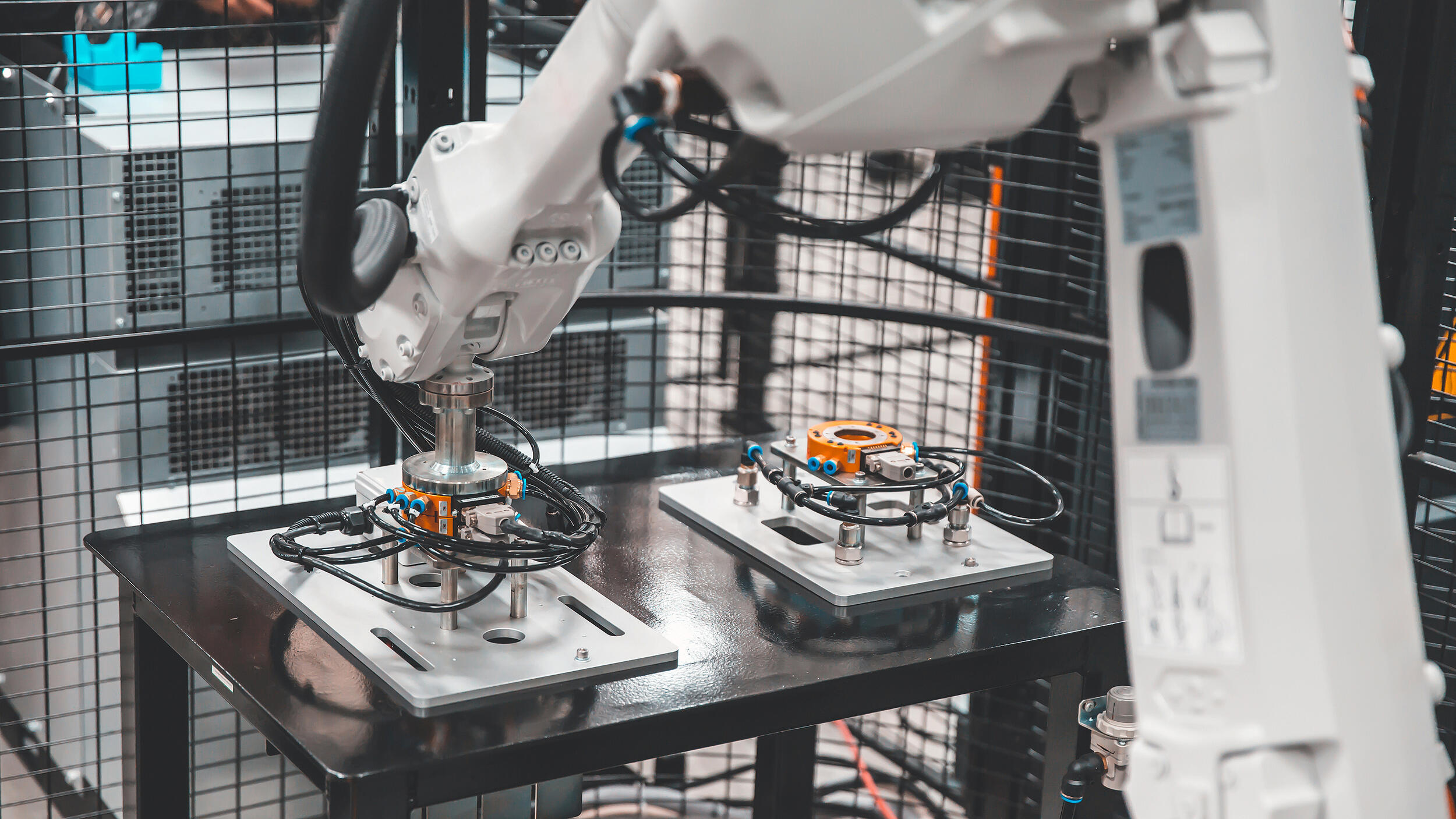 A photo of a robotic arm working on electronics. 