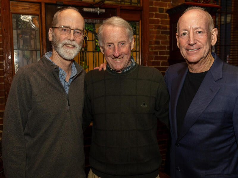 A photo of three men from the waist up. 