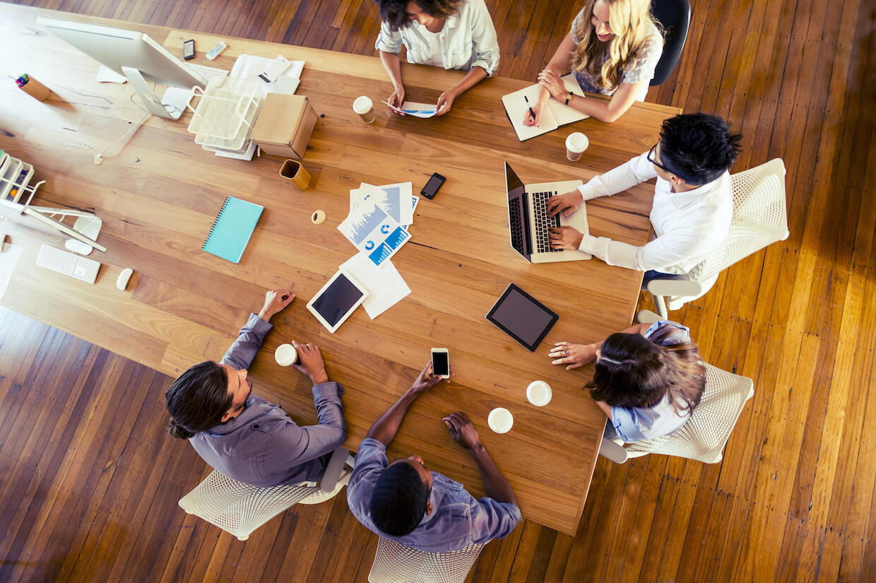 People sitting at a table at a meeting.