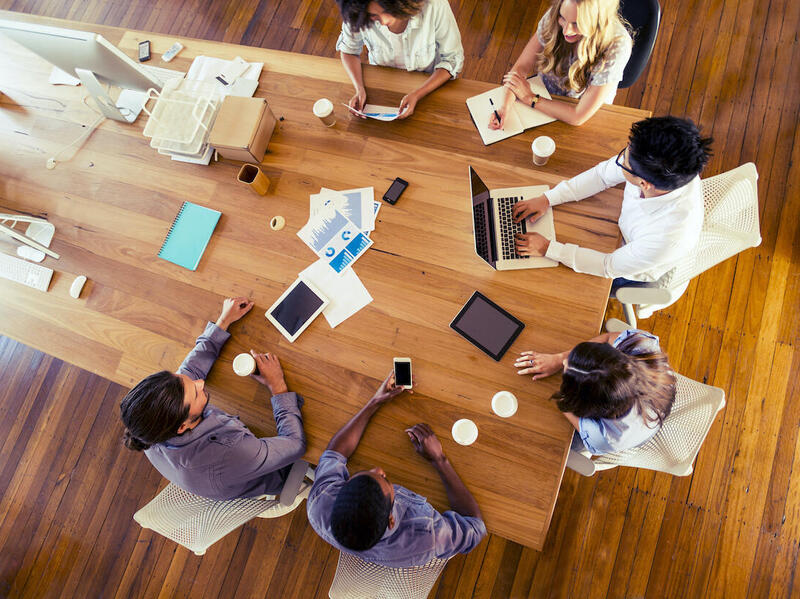 People sitting at a table at a meeting.