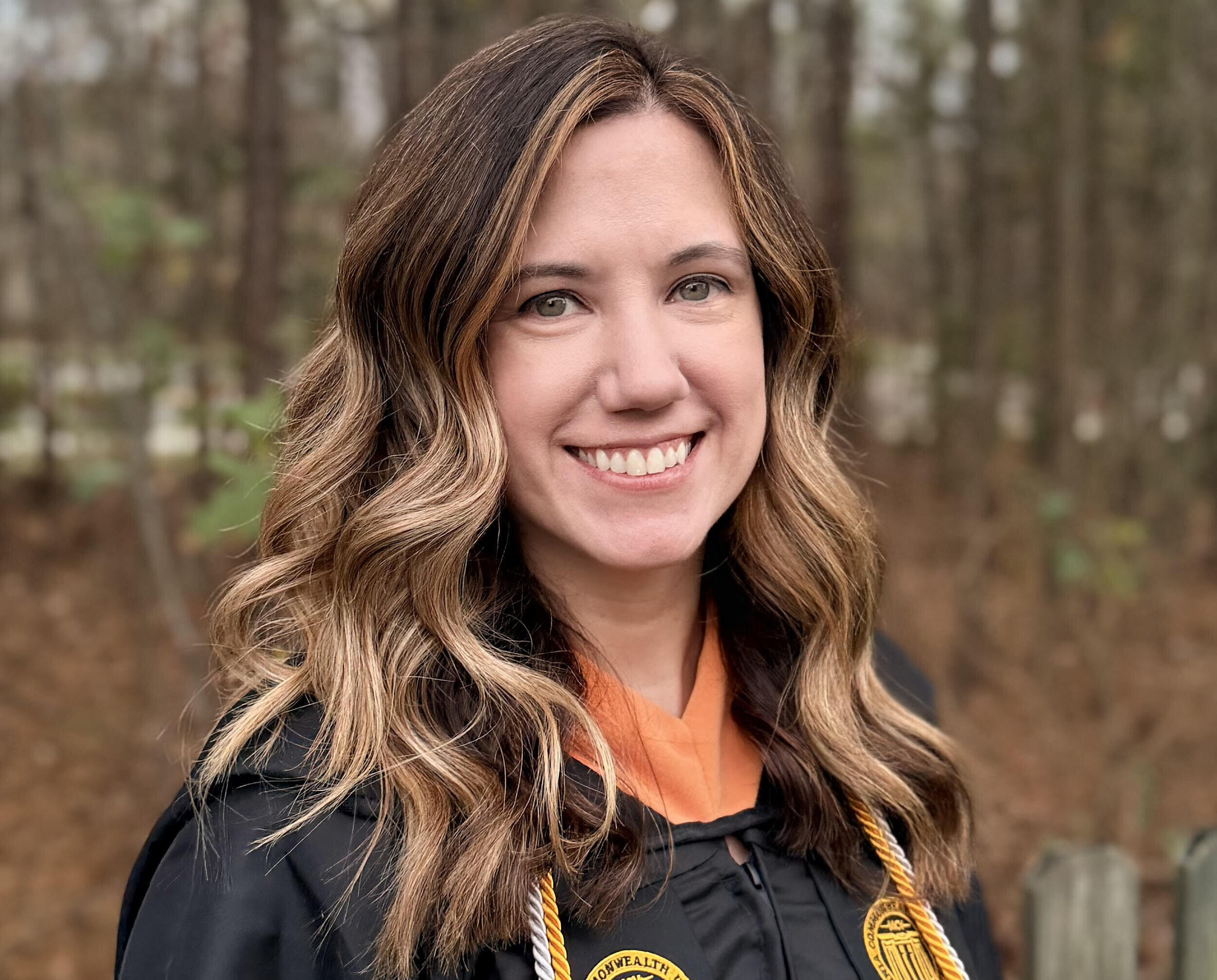 A photo of a woman wearing a graduation gown. 