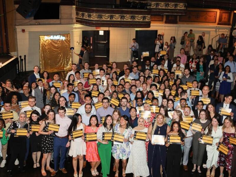 A photo of a large crowd of people holding signs