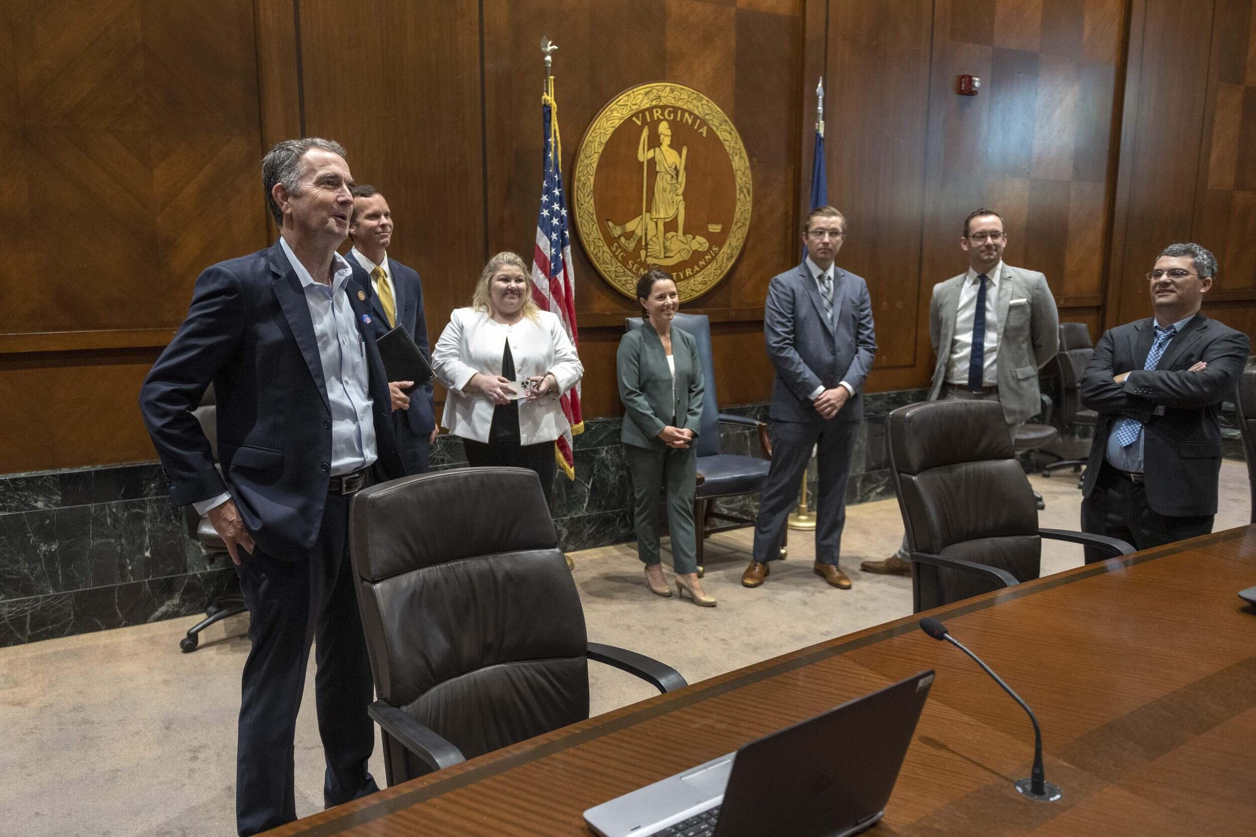 A group of VCU students and others stand around Virginia Gov. Ralph Northam.