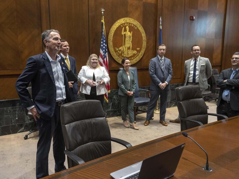 A group of VCU students and others stand around Virginia Gov. Ralph Northam.