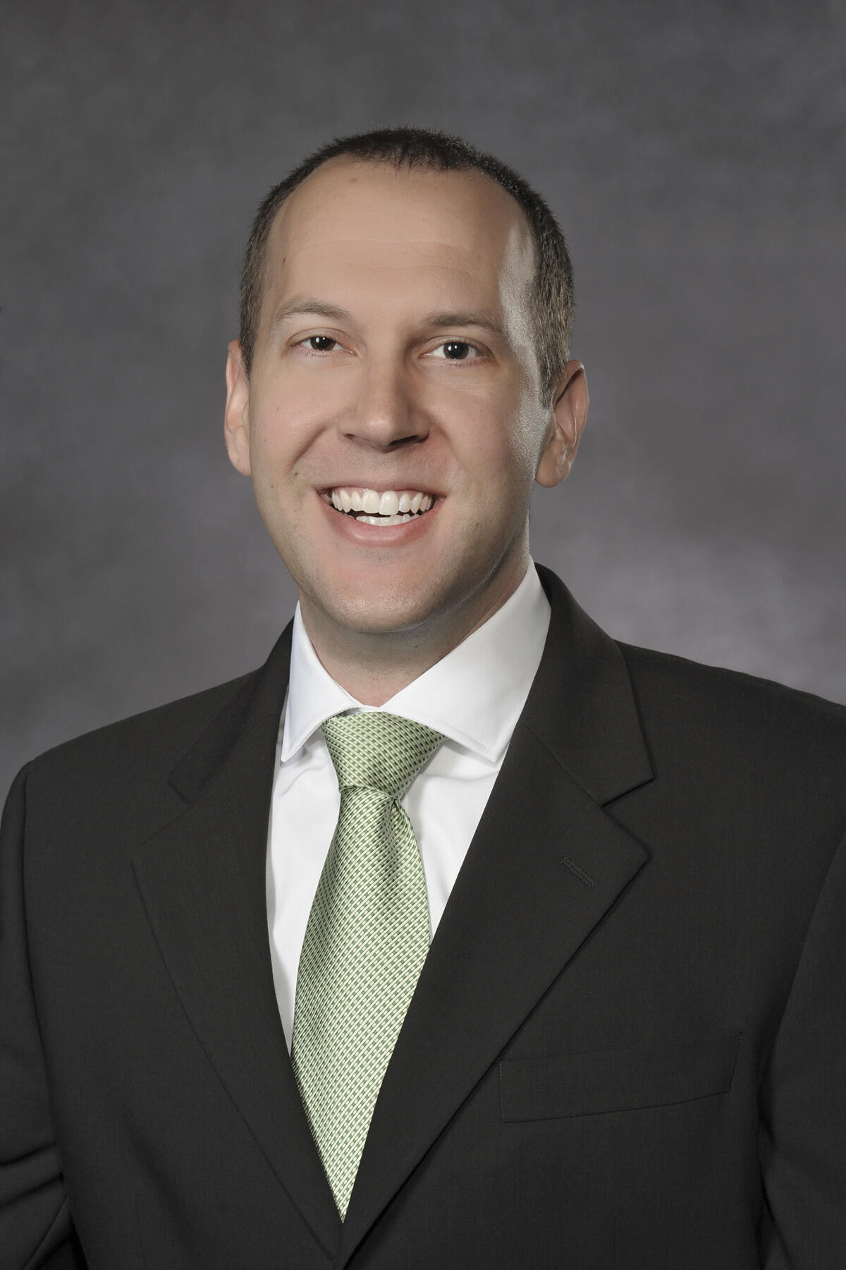 Man in dark suit and green tie.