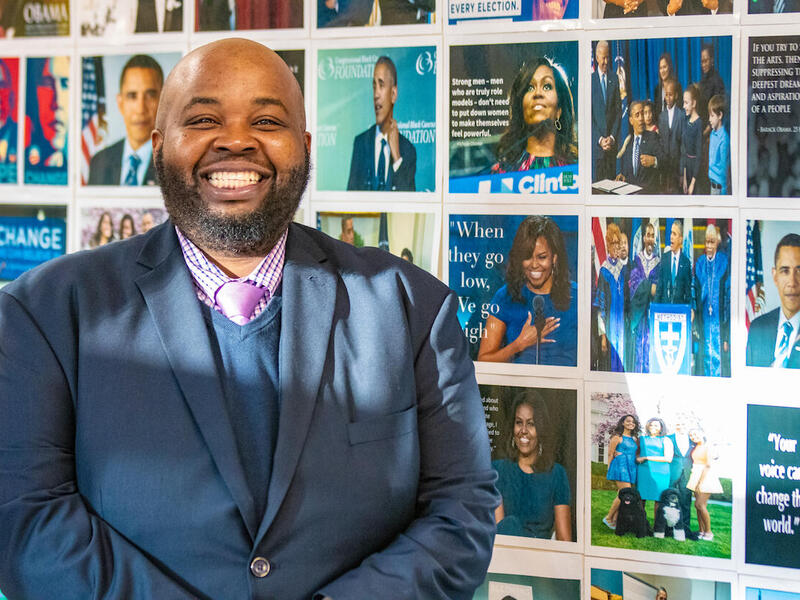 Rodney Robinson stands in the hallway of the Virgie Binford Education Center, which he has decorated with photos of inspiring African Americans.
