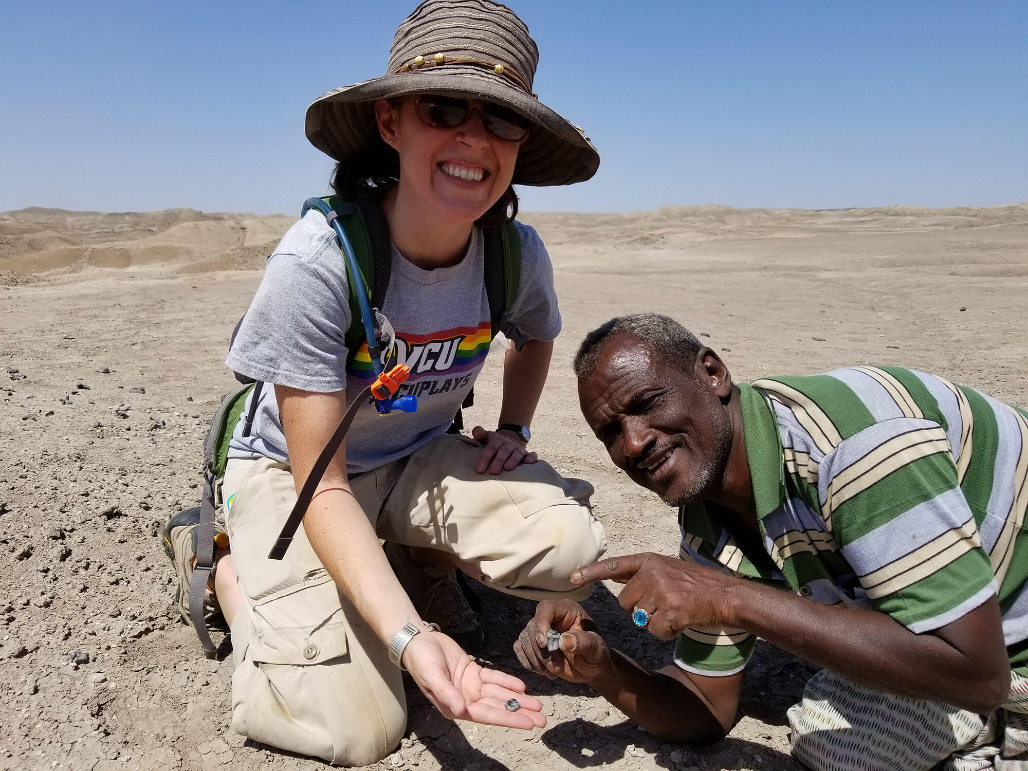 Amy Rector, Ph.D., and Omar Abdullah show off hominin teeth fossils that they found in the Afar region of Ethiopia.