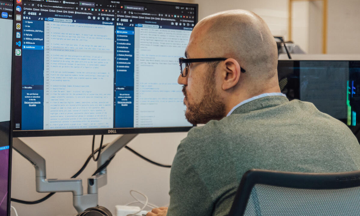 A man in glasses looks at a computer screen.