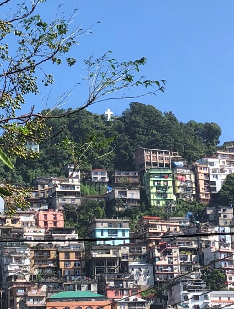 A photo of multistory buildings on a hill. 