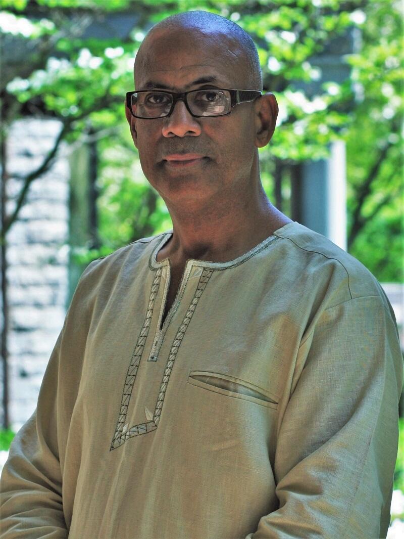 A portrait of a bald man wearing glasses 