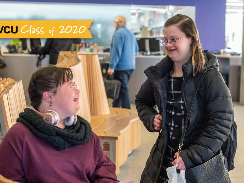 Two students in conversation inside V C U's Cabell Library.