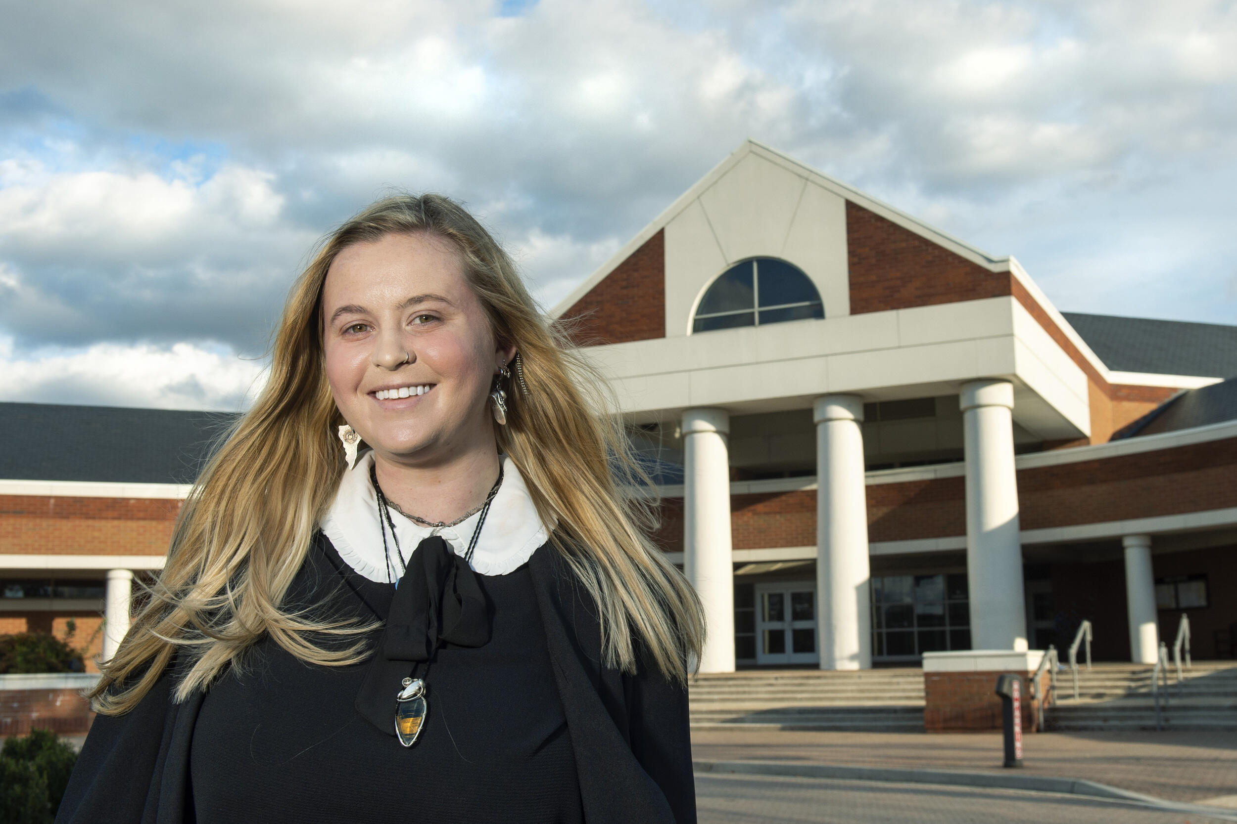 A woman outside in front of a building. 