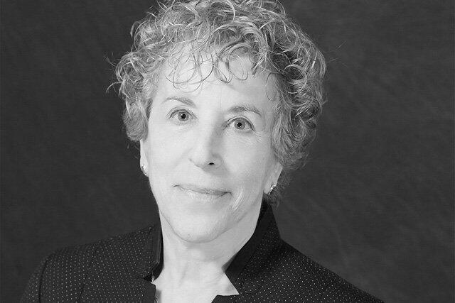 A black and white photo of a woman from the shoulders up. 