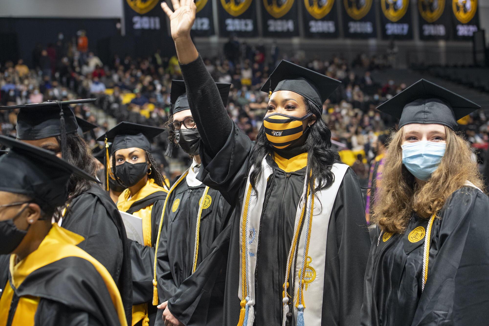 graduates waving at commencement
