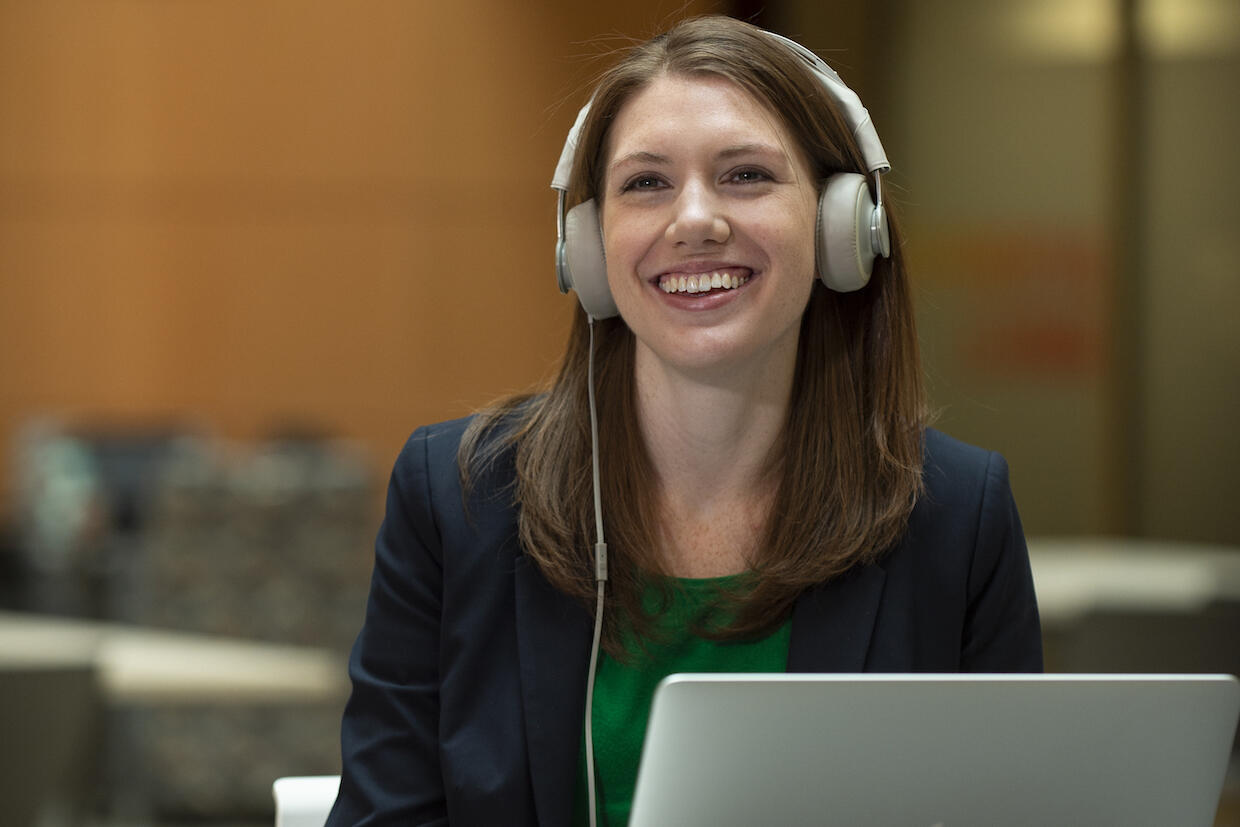 A person wearing headphones smiles.