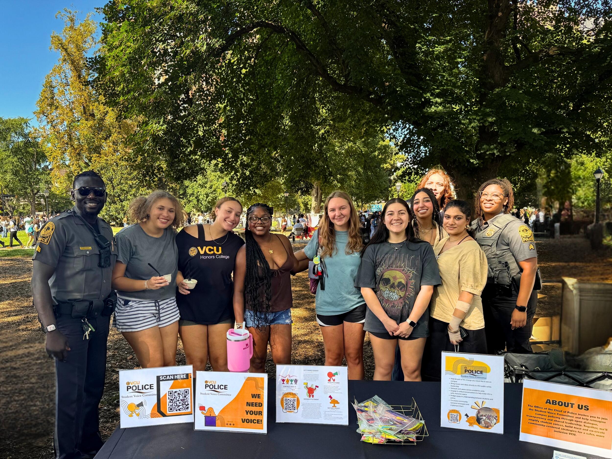 A group photo of eight students and two police officers standing in a part. 