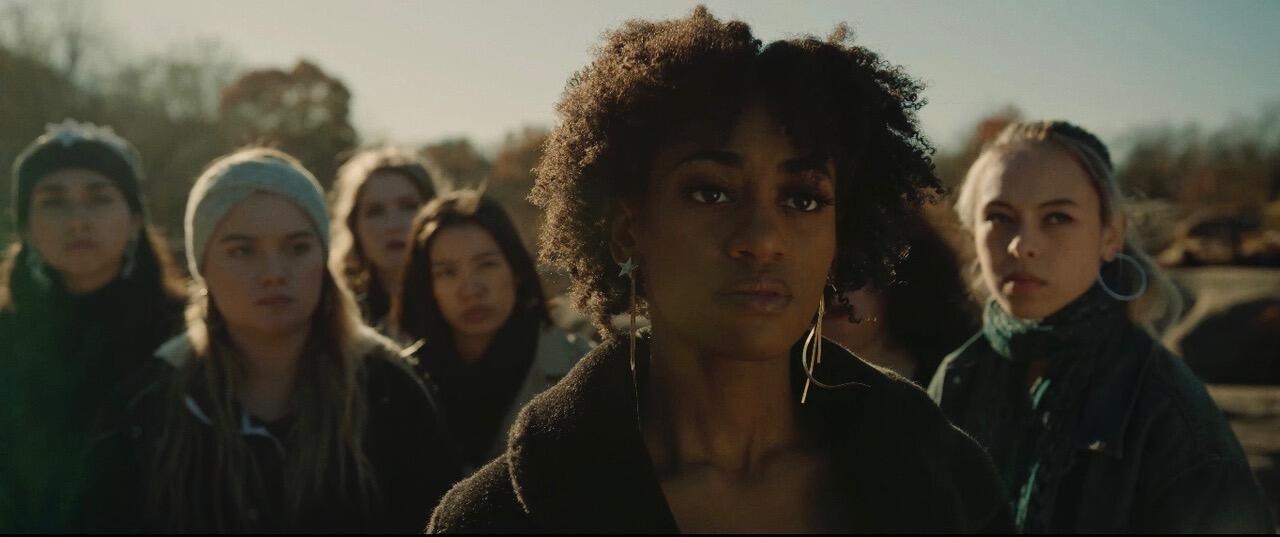 Still from \"Welcome to the Show.\" A group of women staring off camera