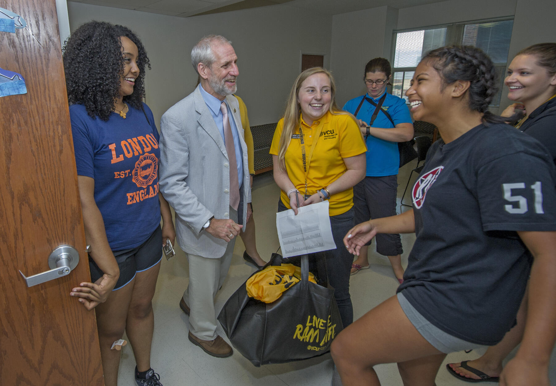 Charles Klink and resident assistant Eleanor Ritzman (in gold polo shirt) speak with two freshmen students. 