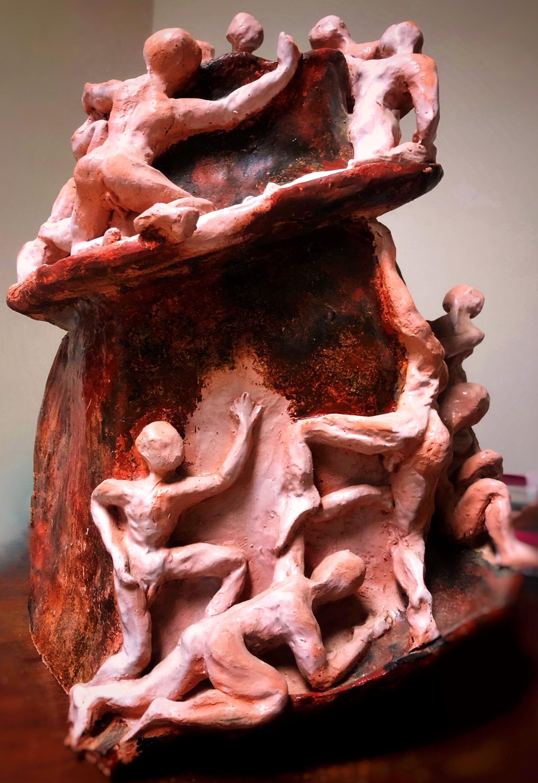 A ceramic sculpture of people climbing a structure 