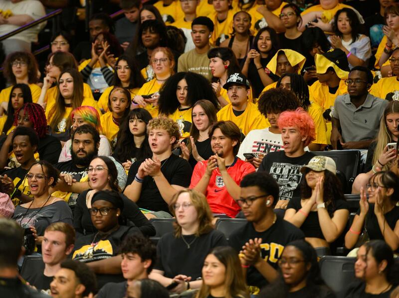 A crowd of students sitting in basketball stands.