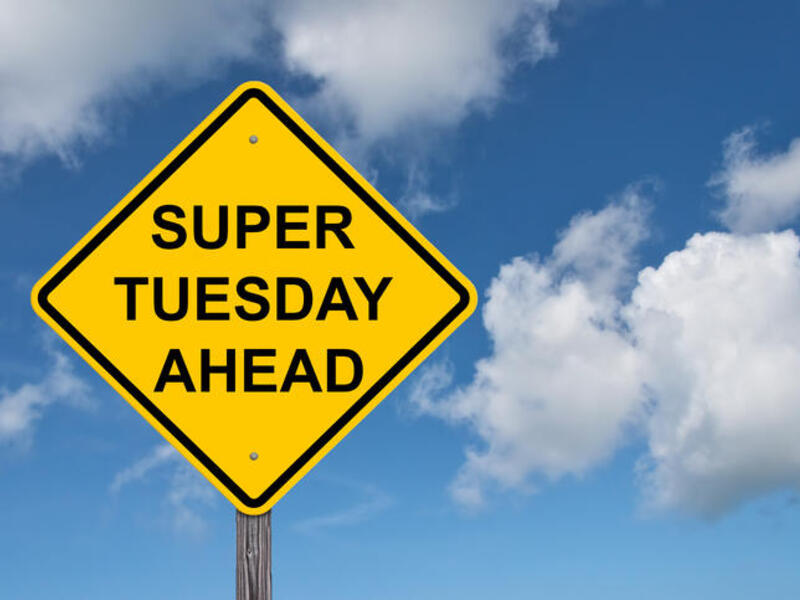 A photo of a yellow caution sign that says \"SUPER TUESDAY AHEAD\" 