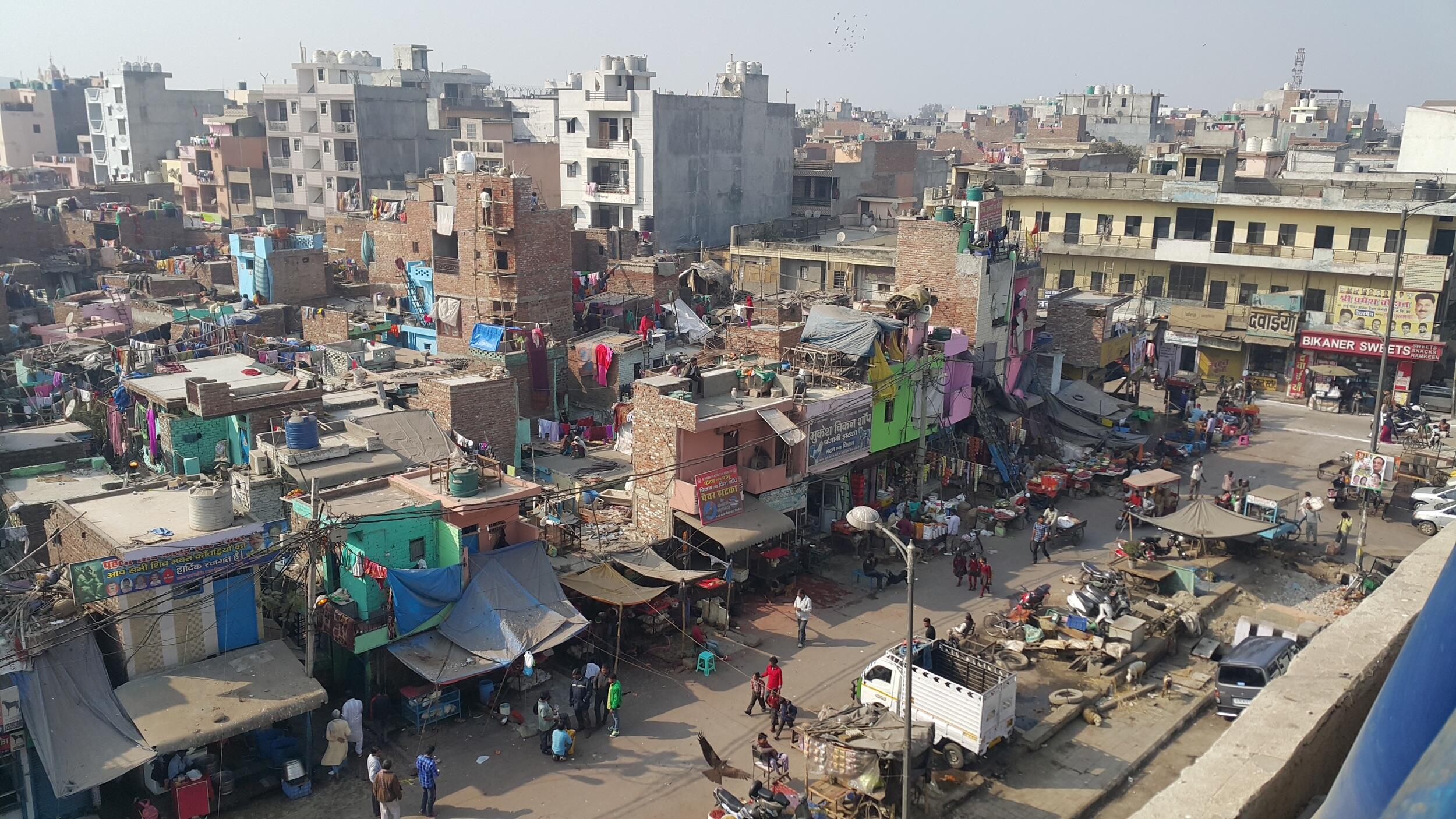 a crowded slum during the day in Delhi, India.