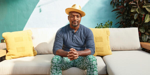 A photo of a man sitting on a couch. 