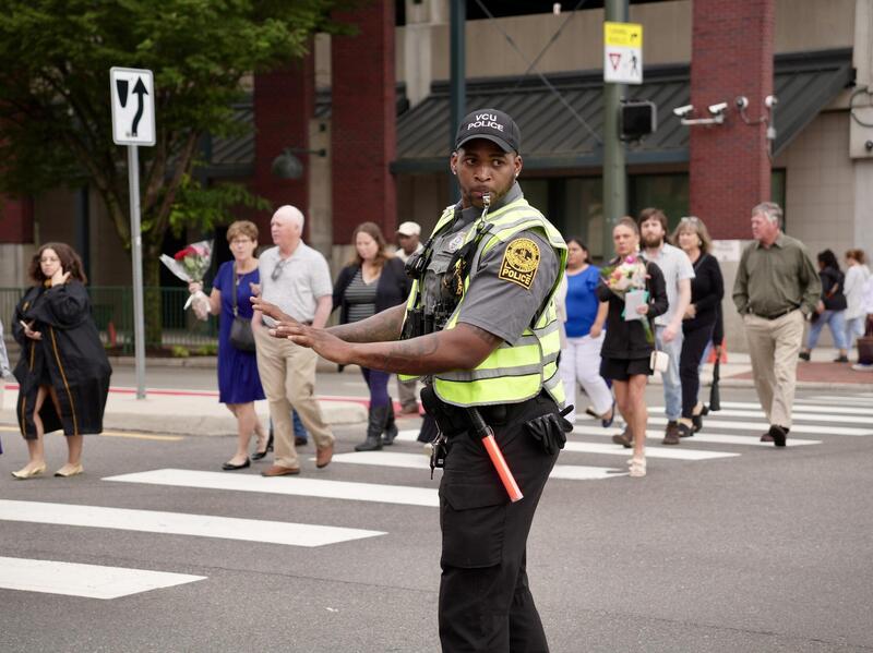 A photo of a traffic cop directing people across a cross walk. 