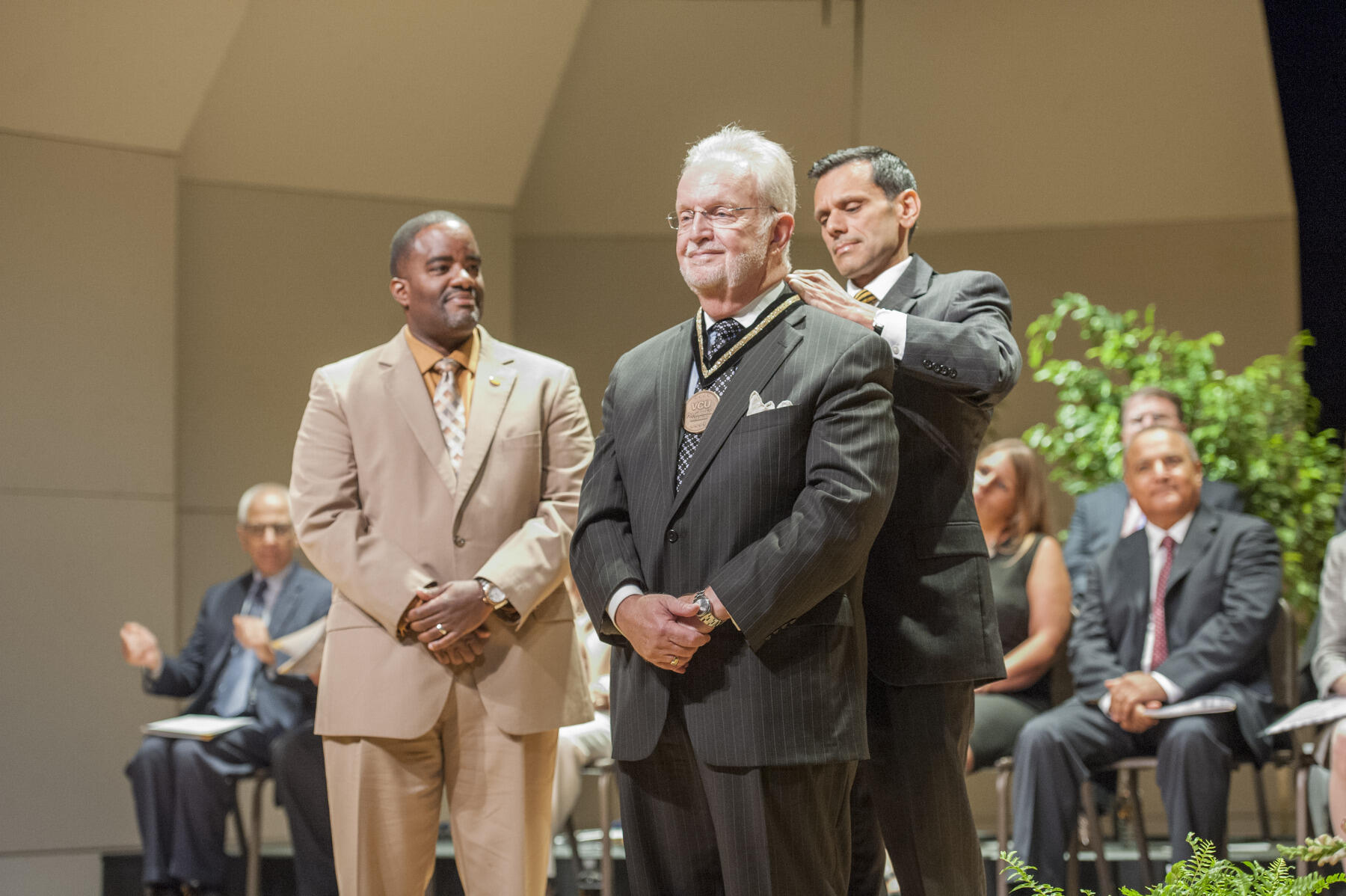 Michael D. Davis, a retired professor in the School of Education, receives the Presidential Medallion from VCU President Michael Rao. (Thomas Kojcsich, University Marketing)