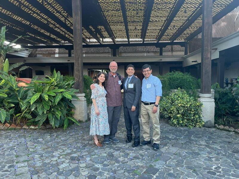 A photo of four people standing in front of a terrace with plants 
