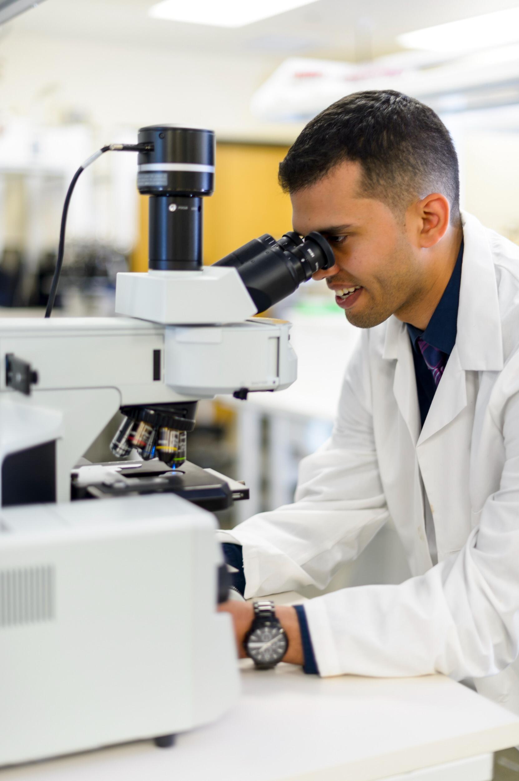 Isaac Rodriguez looking through a microscope