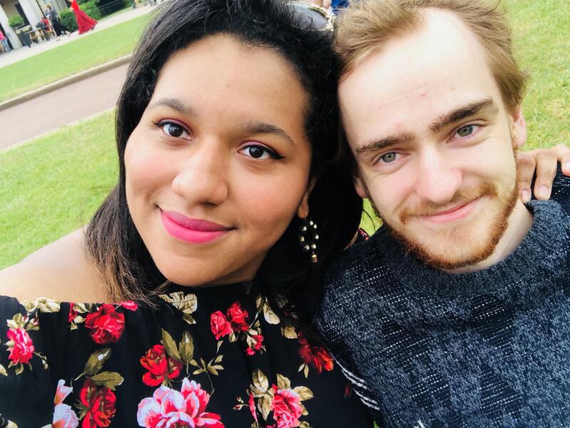 A photo of a woman with her arm around a man's shoulders. 