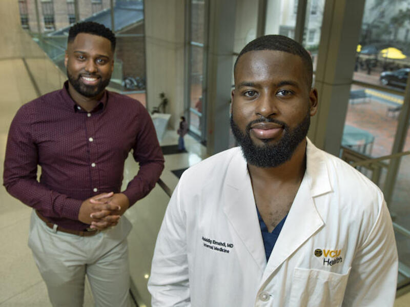 Siddiq Elmahdi stands in the foreground with his mentor, Henry Lewis III, in the background.