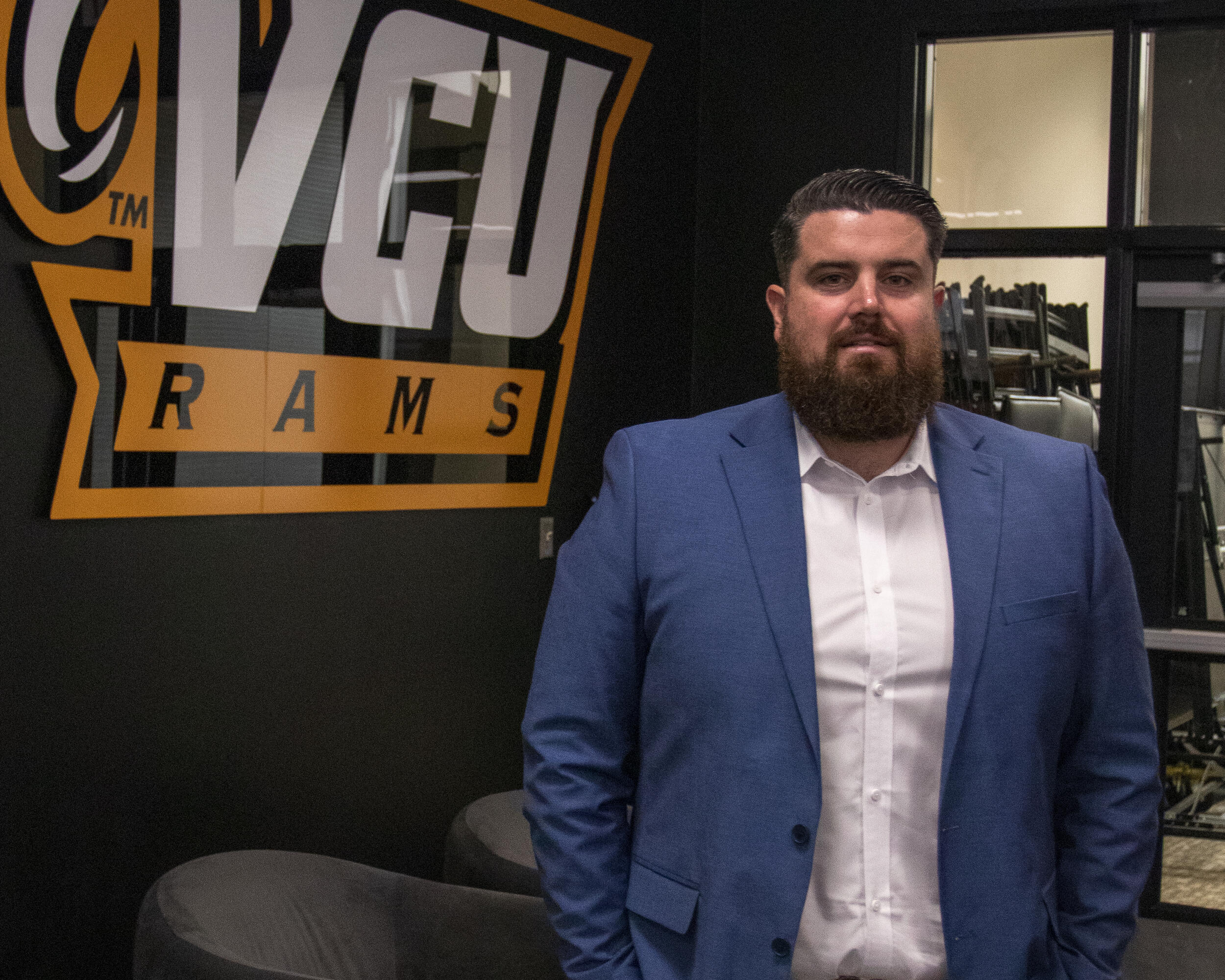 A photo of a man from the waist up. He is wearing a blue sports jacket and a white button up shirt. 