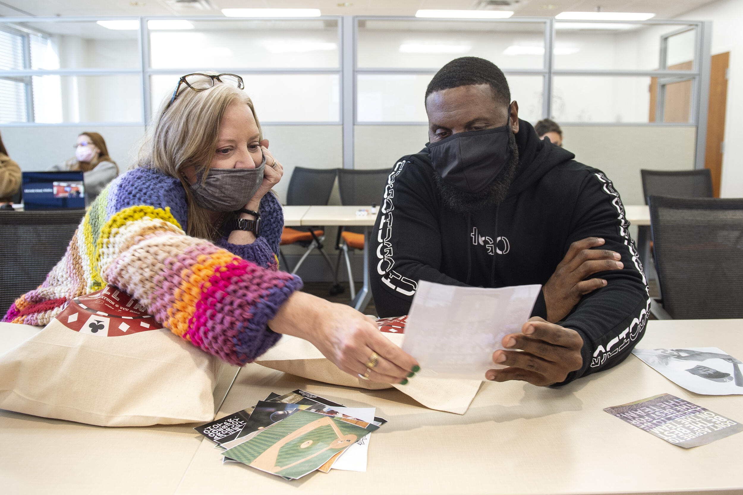 A man and woman holding a piece of paper and looking at it together