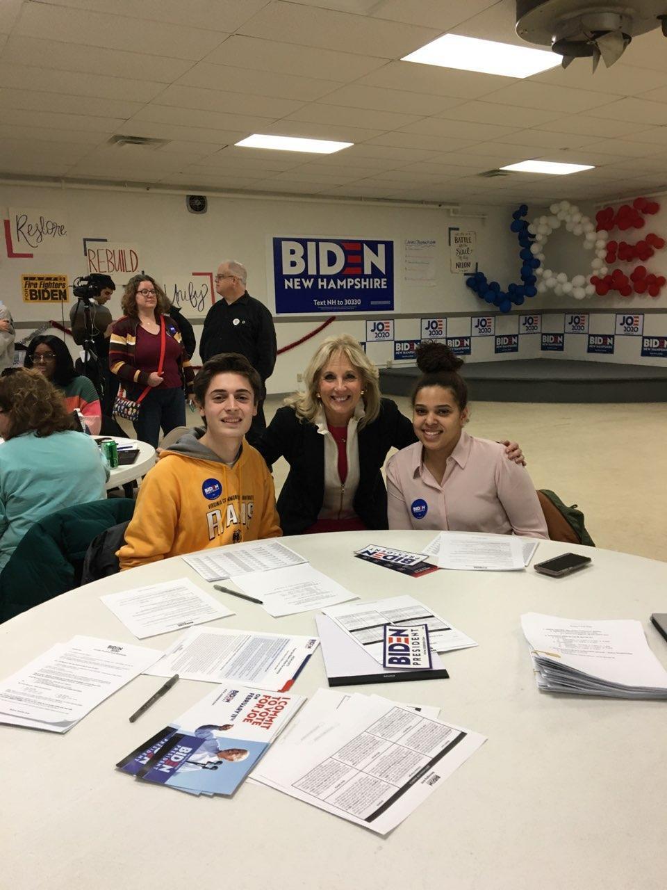 Two students at a table with Jill Biden. 