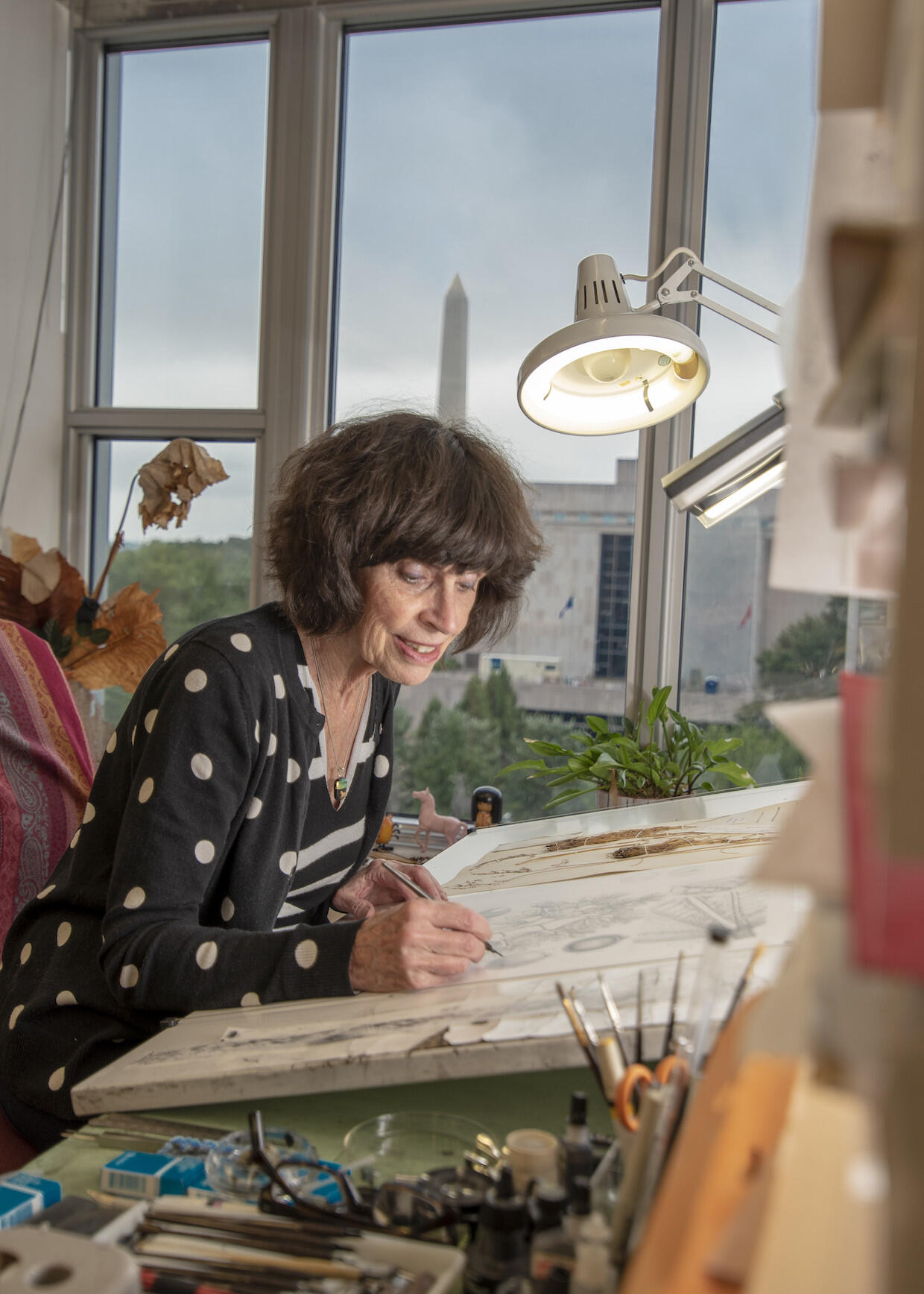 Woman drawing at a desk.
