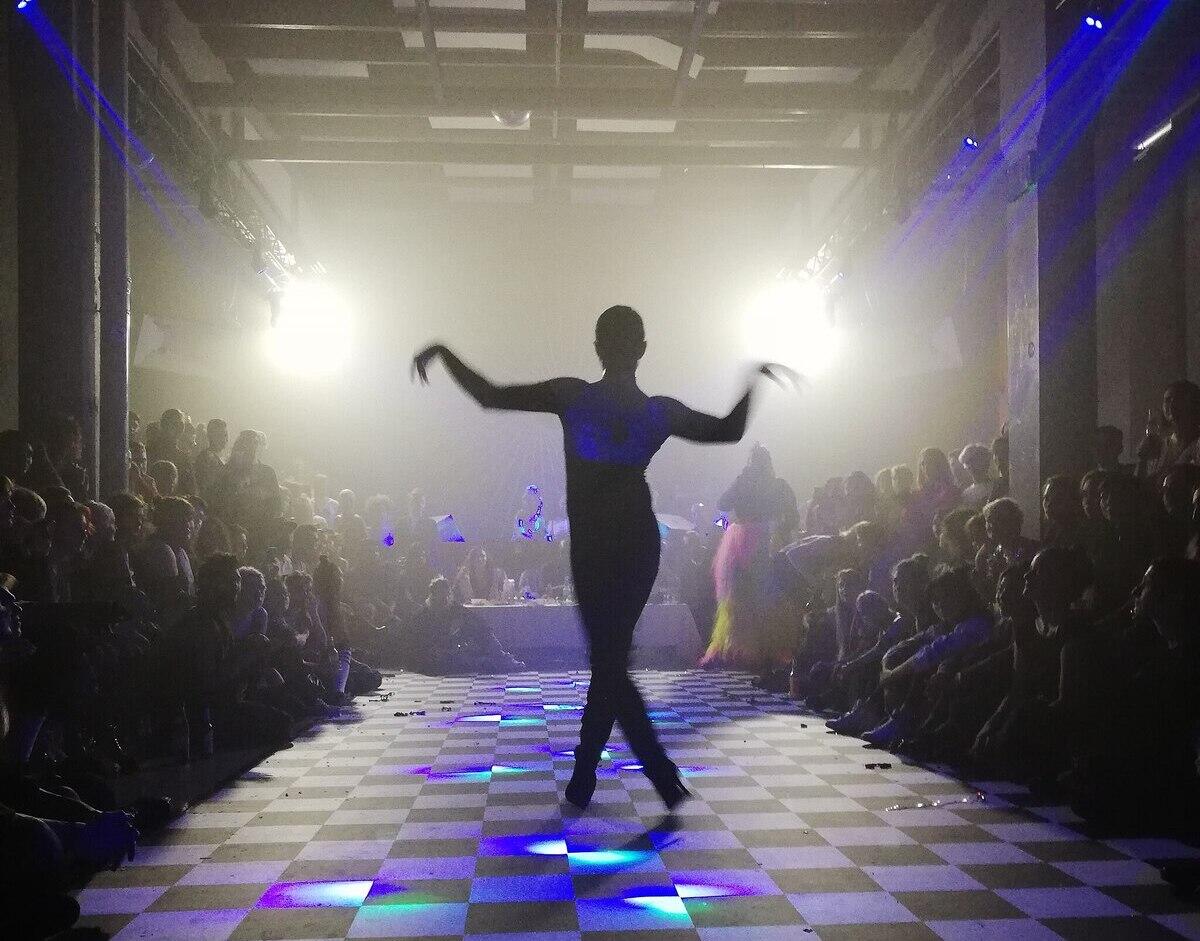 The photo of a silhouette posing on a black and white checkered floor.