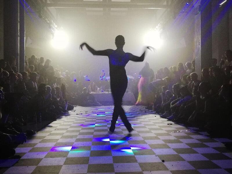 The photo of a silhouette posing on a black and white checkered floor.