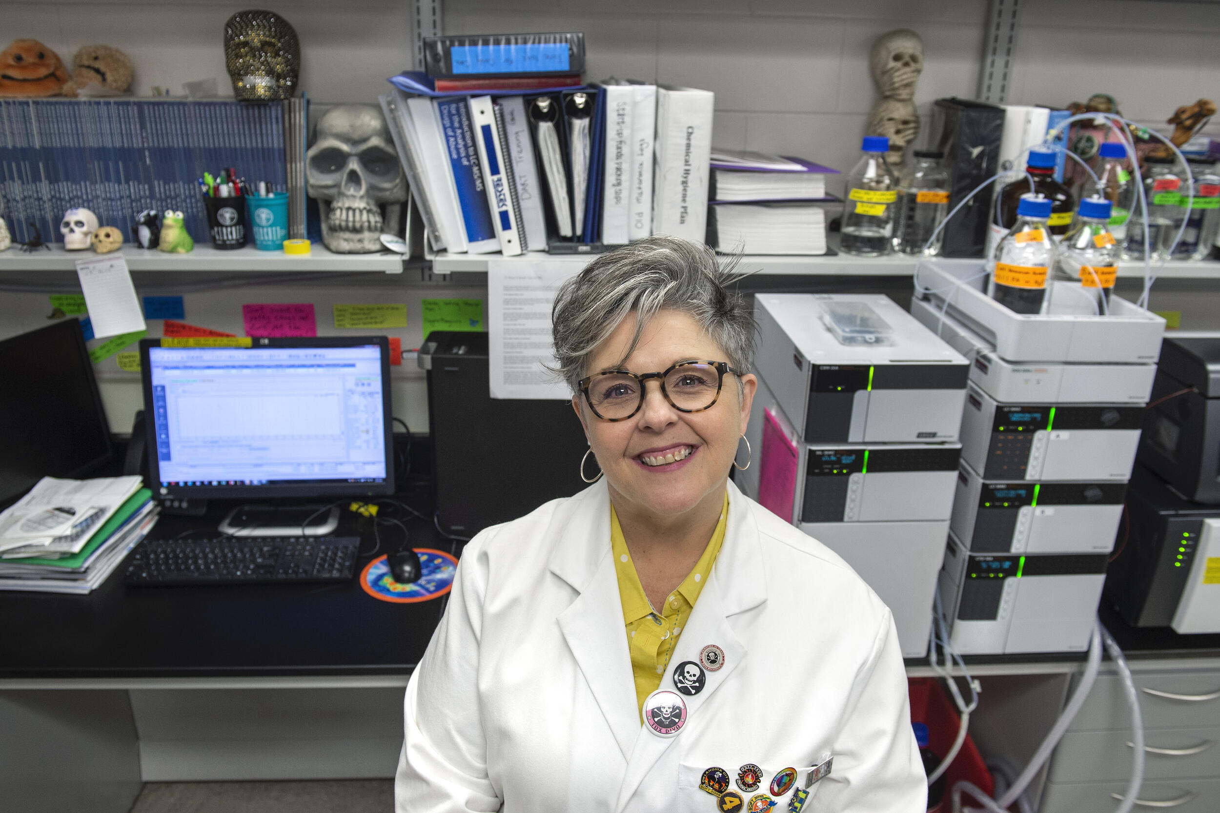 Michelle Peace, Ph.D., sitting in a scientific laboratory.