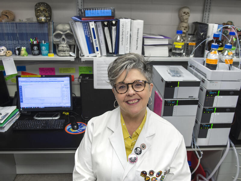 Michelle Peace, Ph.D., sitting in a scientific laboratory.