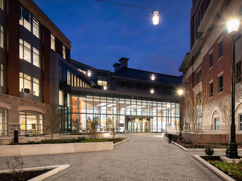 Picture at night in the courtyard of a building with lights on.